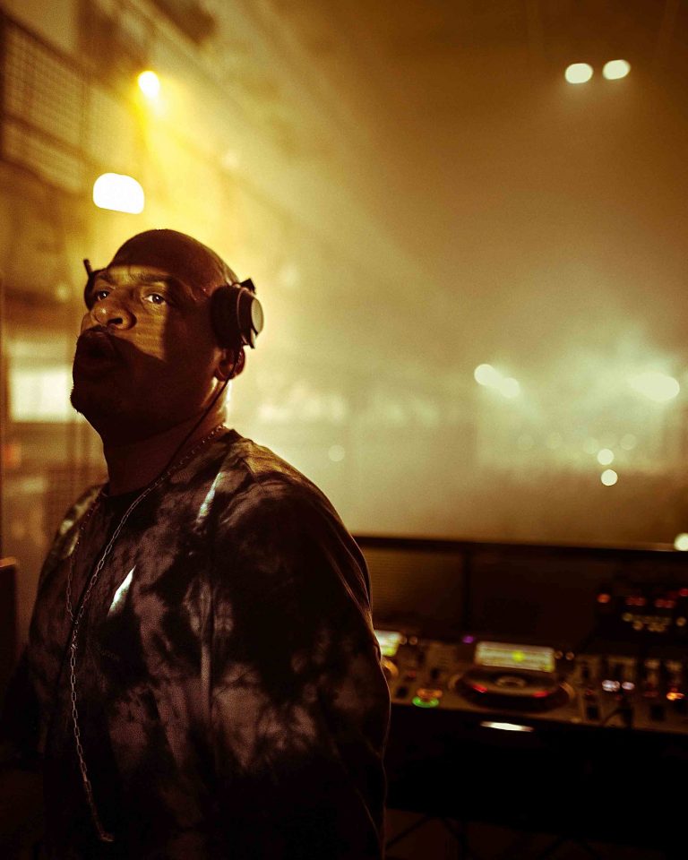 DJ performing at London event with dramatic lighting and smoke, event photography
