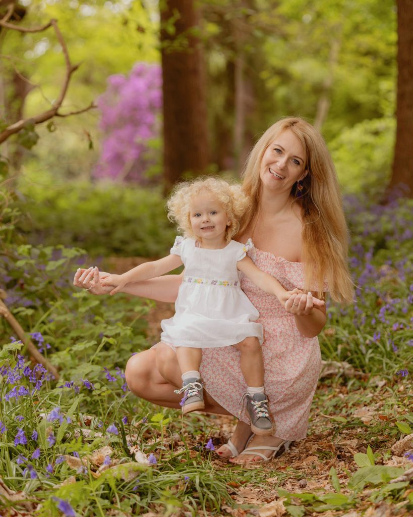 Mother and toddler smiling together in a bluebell woodland, natural relaxed family photography in London
