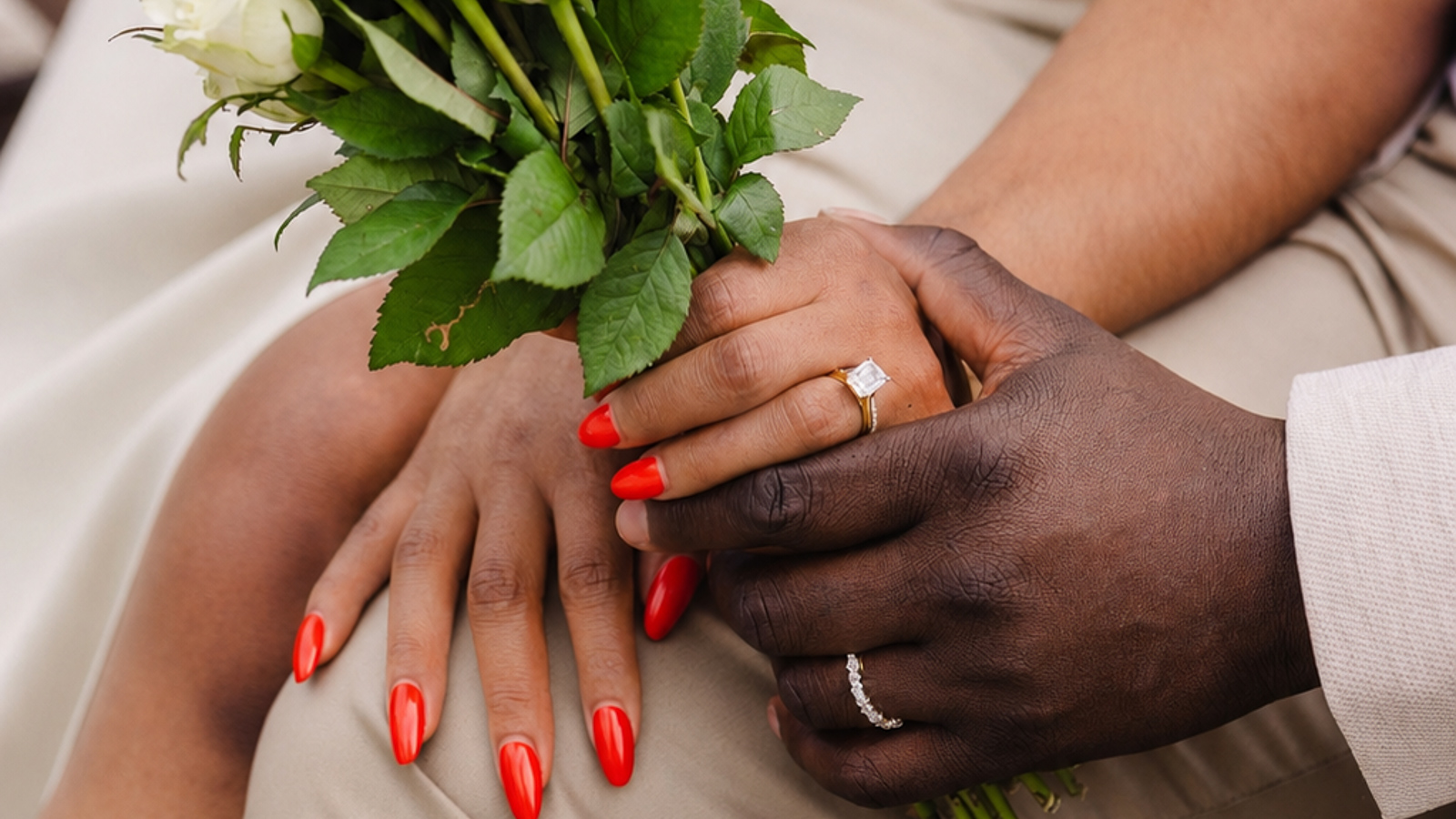 Bride and groom holding bouquet showing wedding rings at a London registry office wedding
