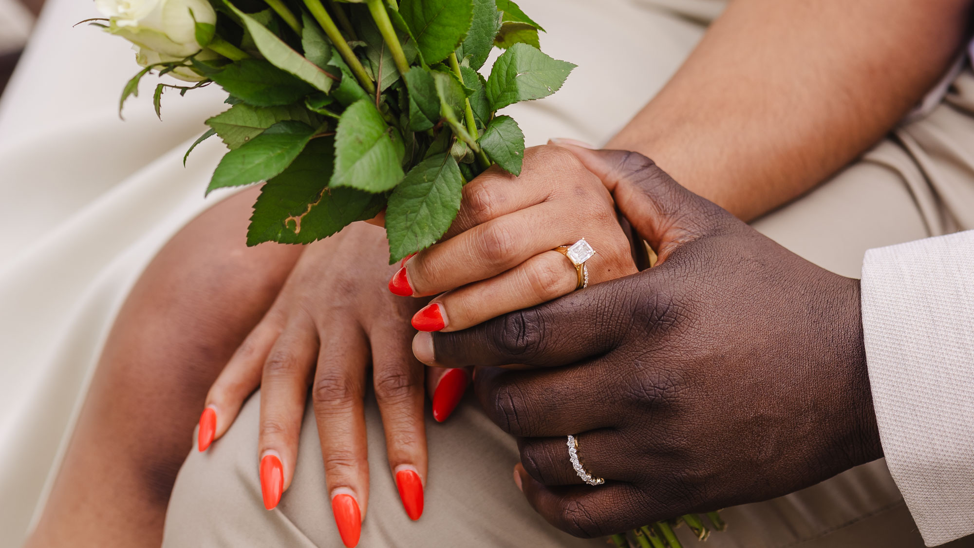 Couple holding hands and bouquet during an intimate registry office wedding in London