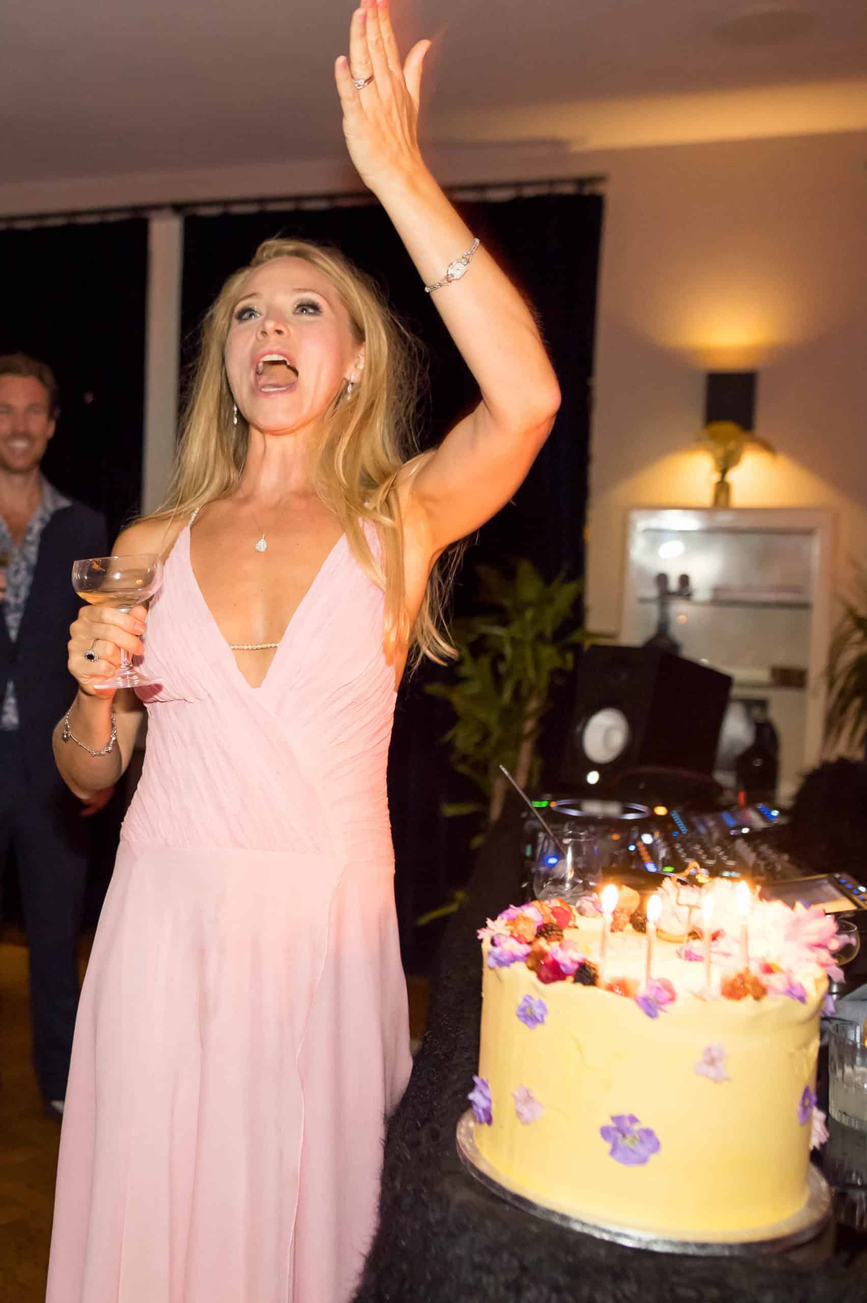 Woman celebrating at a birthday party with a birthday cake and DJ in London