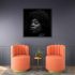 Gemma black and white portrait artwork displayed above orange chairs in a contemporary interior