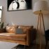 Hitchcock black and white artwork displayed above a leather sofa in a modern interior